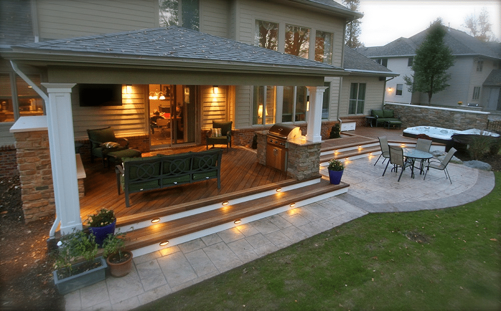 Outdoor garden design combining composite decking and stone paving for added depth and texture.