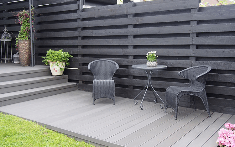 Small garden with light-colored decking that reflects light, creating the illusion of a larger outdoor space