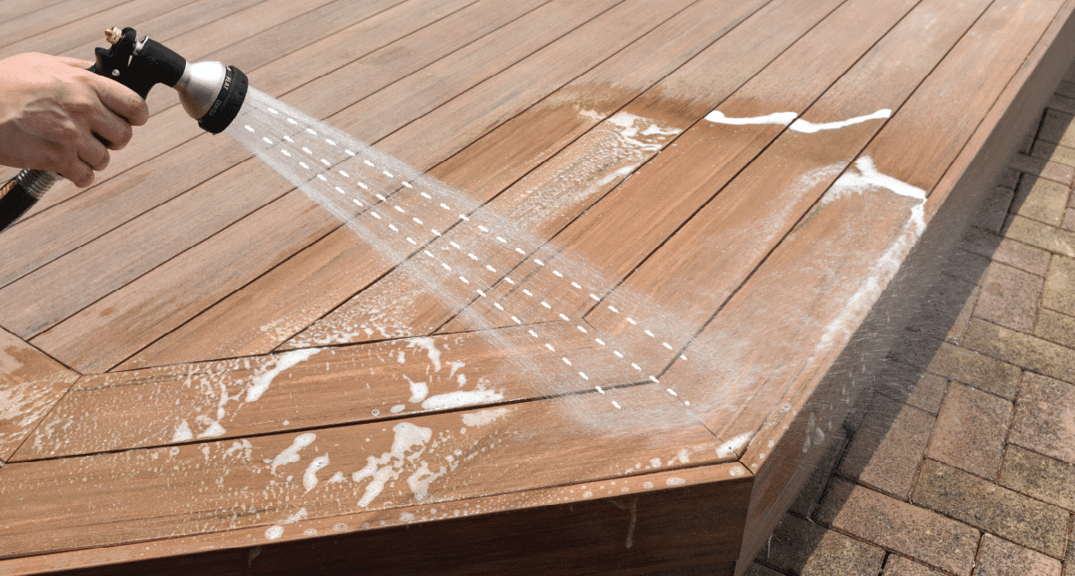 Professional power washing composite decking with low pressure and wide fan nozzle for safe, effective cleaning.